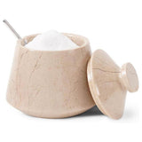 Beige stone container with lid and spoon, filled with white substance on a white background