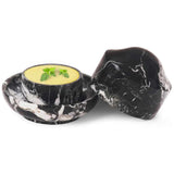 Black marble butter crock with lid, showing butter inside on a white background.