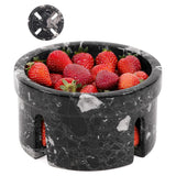 Black marble-patterned container filled with strawberries on a white background