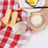Marble butter crock with butter served alongside toast on a breakfast table.