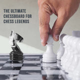 Hand moving a white chess piece on a chessboard with text 'The Ultimate Chessboard for Chess Legends'.