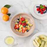 Fruit bowl with mixed fresh fruits on a kitchen table.