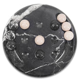 Black marble game with decorative stones on a white background