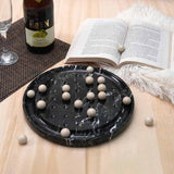 A luxurious black marble solitaire board with white marble pieces