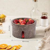 Marble bowl filled with strawberries on a table with measurements indicated.