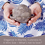 Person holding a small marble butter keeper.
