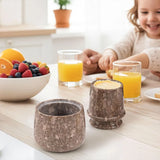 Black marble butter keeper on a family breakfast table with juice and fruit.