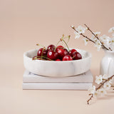 White bowl filled with cherries.