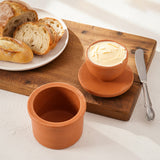 Terracotta Butter Keeper with butter and bread on a wooden board