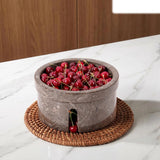 Bowl filled with cherries on a woven mat