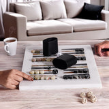 Two people playing backgammon on a wooden table with a cup of coffee and dice.