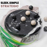 Decorative stone with black and white marble pattern and round stones on a light background.