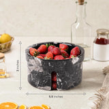 Black marble bowl with strawberries on a table, showing dimensions.