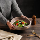 Person holding a bowl of salad