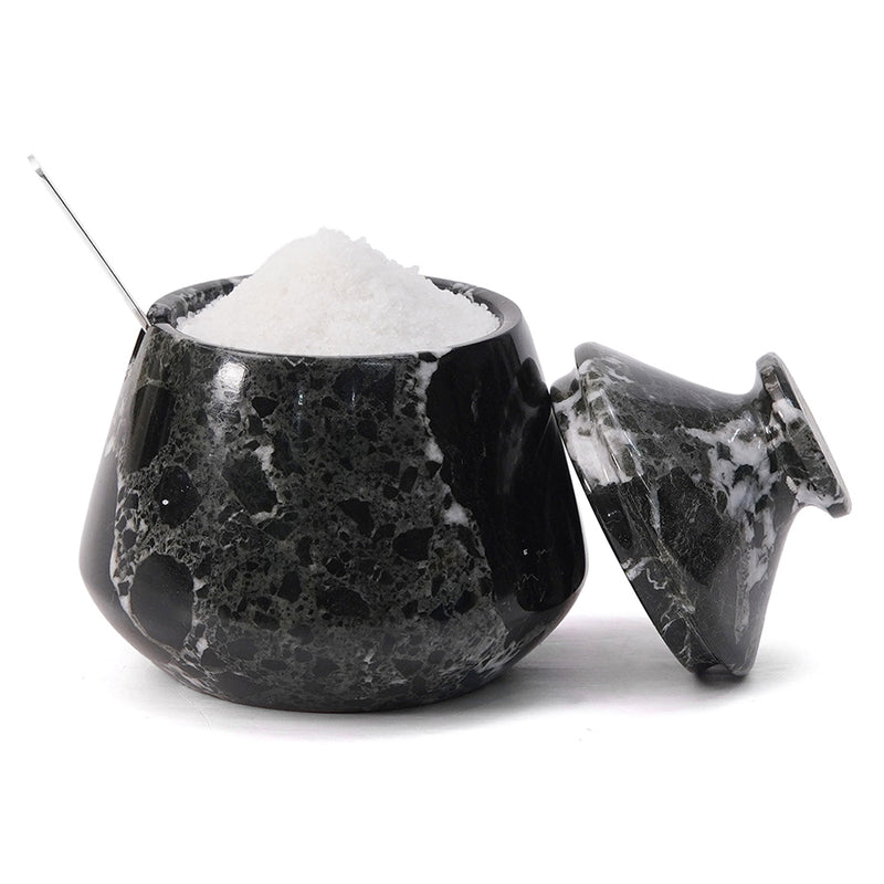 Black marble salt shaker with white salt inside on a white background