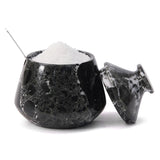 Black marble salt shaker with white salt inside on a white background