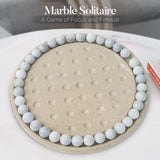 Marble Solitaire game with marble stones on a beige board