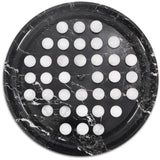 Round black marble tray with white round items on a white background