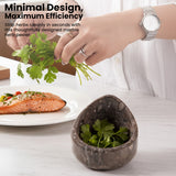 Marble herb peeler with herbs next to a plate of food on a table.