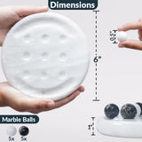 White round board game held by hands with marble balls and dimensions displayed.