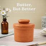 Terracotta butter dish on a table with flowers and a knife, featuring text 'Butter, But Better'.