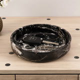 Black marble-patterned tray with keys and a car key on a wooden surface