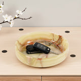 Marble-patterned tray with keys on a wooden surface with cherry blossoms in the background