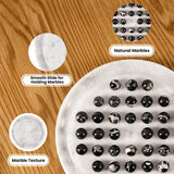 A white marble tray holding multiple black-and-white marbled stones, shown on a wood surface with three callout circles labeled 'Smooth Slide for Holding Marbles,' 'Natural Marbles,' and 'Marble Texture.'.