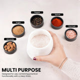 A hand holds a white salt cellar containing coarse pink salt, surrounded by six small black bowls labeled Pepper, Sugar, Spices, Pink Salt, Almonds, and the product itself. The brand Earthen Crafts is visible in the top left, and text at the bottom reads 'MULTI PURPOSE'.