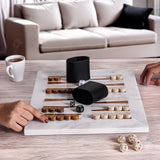 Board game being played on a marble board with dice and pieces, in a living room setting.