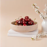 Natural marble fruit bowl used for serving fresh cherries.