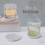 Two glasses with lemon slices on a white surface, featuring 'Unique by Nature' text.