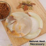 marble green onyx salt magnet candy  with a natural product on a wooden board with spices in the background.