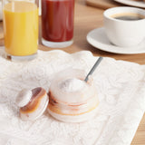 Marble salt and pepper shakers on a table with drinks in the background