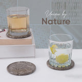 Two glasses with lemon slices on a white surface, featuring 'Unique by Nature' branding.