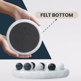 Hand holding a round black mini board game with a felt bottom, showing its texture.