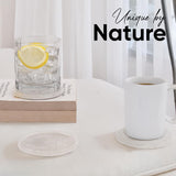 Glass of water with lemon, white mug, and books on a light surface with 'Unique by Nature' text.