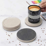 Set of round marble coasters on a white surface with a coffee cup.