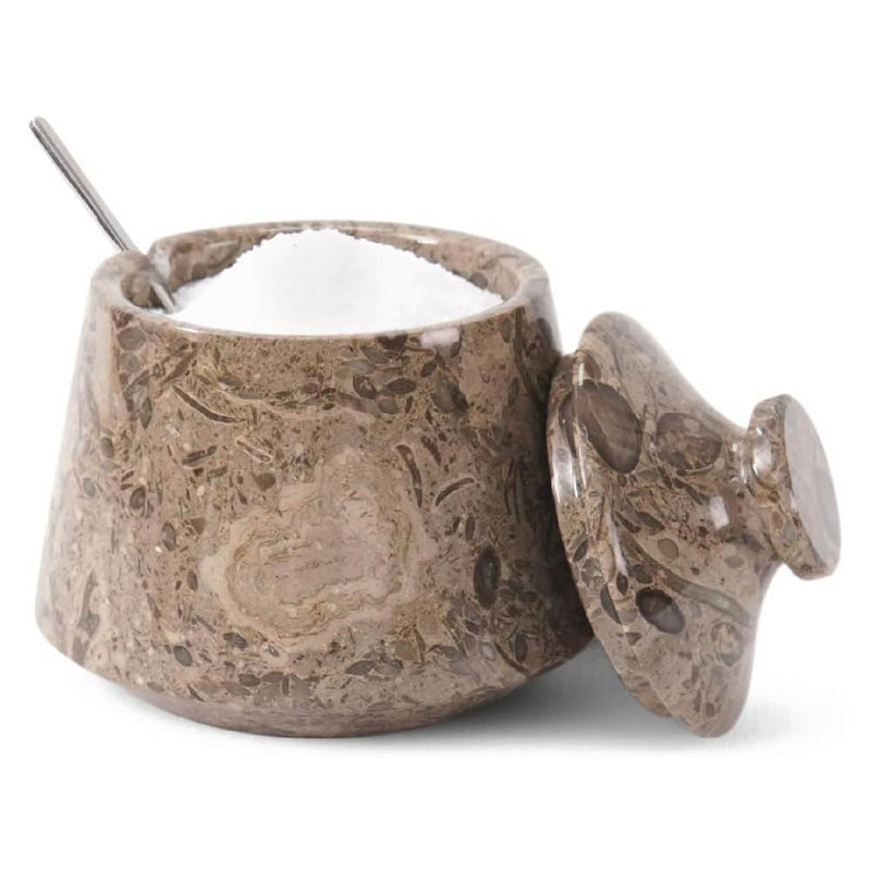 Decorative stone sugar container with a spoon on a white background