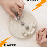 Two hands reaching towards a board game with marbles, labeled 'Player 1' and 'Player 2'