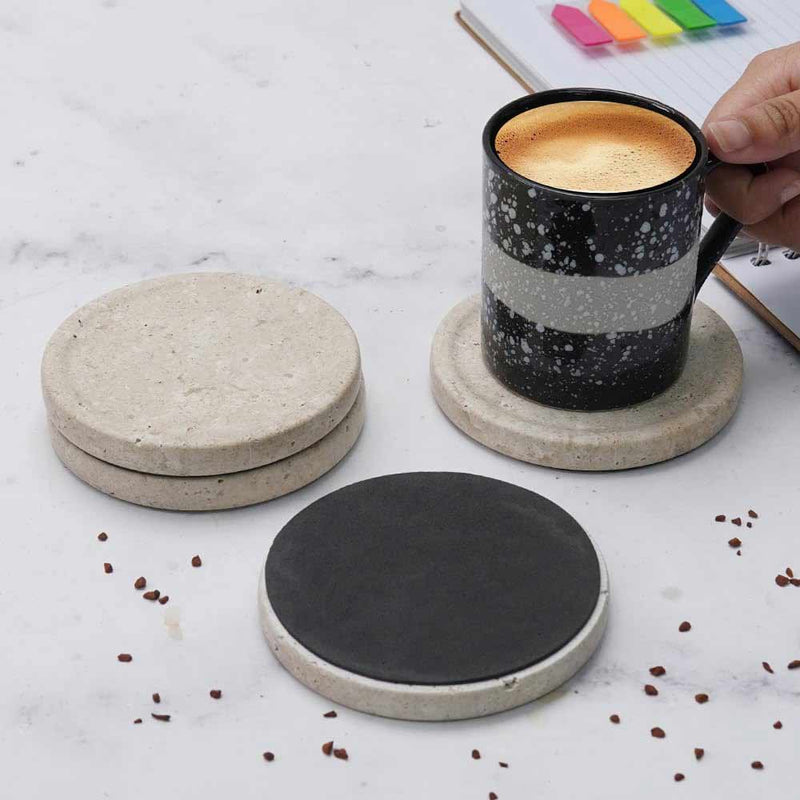 travertine marble coasters on a marble surface with a coffee mug.