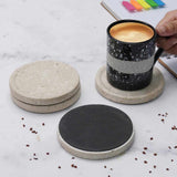 travertine marble coasters on a marble surface with a coffee mug.