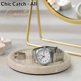 Silver watch on a marble coaster with 'Chic Catch'