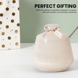 A cream marble jar with a matching lid and a delicate floral ribbon bow, shown alongside a gold polka dot gift bag. The text 'PERFECT GIFTING' is displayed at the top.