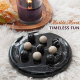 Marble moves game with marbles on a marble board, candle, and flowers in the background.