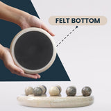 Hand holding a round stone with a felt bottom, showing its texture and use.