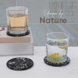Two glasses with lemon slices on black marble coasters, with 'Unique by Nature' branding.