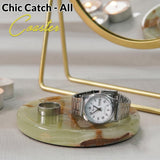 Silver watch on a decorative coaster with 'Chic Catch'