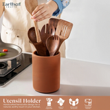 Wooden utensils in a terracotta holder on a kitchen counter with 'Earthen Crafts' branding.