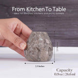 Hand holding a small stone container with measurements and text about its use and capacity.